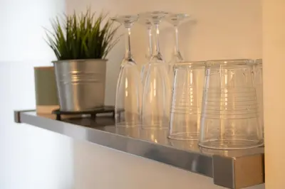 a shelf with glass vases and a plant on it at Casetta Vaticano in Rome
