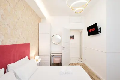 a bedroom with a white bed and a red headboard at 5 minutes from the Vatican - Elegant flat - Wi-Fi in Rome