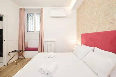 a bedroom with a white bed with a red headboard at 5 minutes from the Vatican - Elegant flat - Wi-Fi in Rome