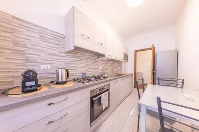 a kitchen with white cabinets and a stove top oven at Easy Host Apt Casa Numitore in Rome