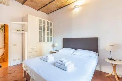 a bedroom with a large white bed with three pillows at Maison Colosseo in Rome