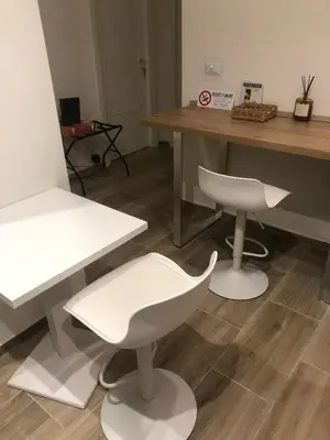 a salon with two white chairs and a table at B&B Rome Vatican Residence in Rome