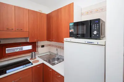 a kitchen with a white refrigerator and a microwave at La Casa di Piero in Rome