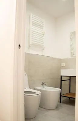 a bathroom with a tub and a toilet and a sink at Lilium Suites in Rome