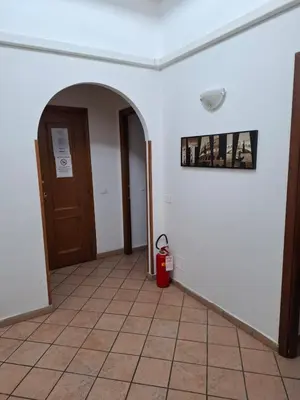 an empty hallway with a door and a fire extinguisher at APARTAMENTO NAPOLEONe 38 in Rome