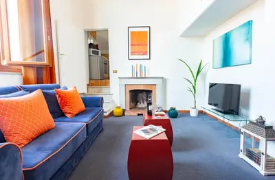 a living room with a blue couch and a fireplace at Spanish Steps Luxury Apartment in Rome