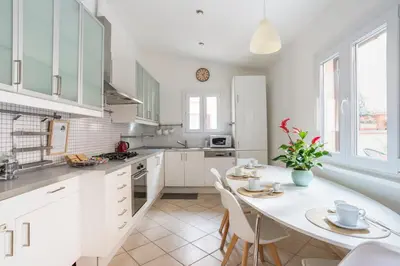 a kitchen with white cabinets and a table and chairs at Terrazza San Lorenzo - Luxury Apartment - Roma Centro in Rome
