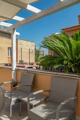 a patio with chairs and a palm tree on a building at St Peter Clivo 1 by BuddyRent in Rome