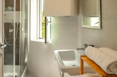 a white bathroom with a sink and a shower at St Peter Clivo 1 by BuddyRent in Rome