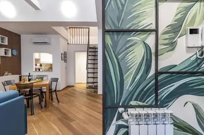 a living room and dining room with a mural on the wall at Italian Experience-Suite Trastevere in Rome