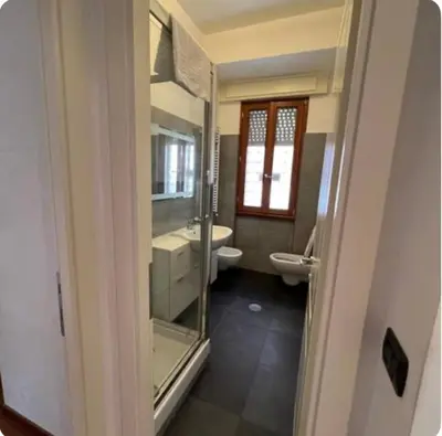 a bathroom with a toilet and a sink and a mirror at Maison del Forte Boccea 108 in Rome