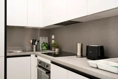 a kitchen with white cabinets and a counter top at Urban Oasis near Termini, free Parking&Patio, int3 in Rome