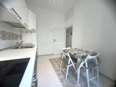 a small kitchen with a table and a sink at Rome Ostiense Apartment in Rome