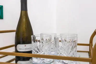 a bottle of wine and glasses on a table at Casa Fen Palazzo Storico - Re di Roma metro A - 2camere2bagni in Rome