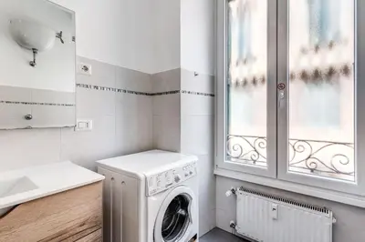 a laundry room with a washing machine and a window at Vatican Eagle Rooms in Rome