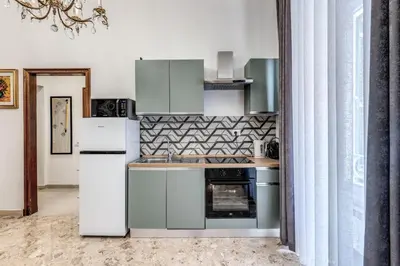 a kitchen with a refrigerator and a stove at Vatican Eagle Rooms in Rome