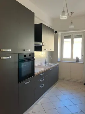 a kitchen with gray cabinets and a sink at FAIROME Apartment Albricci in Rome