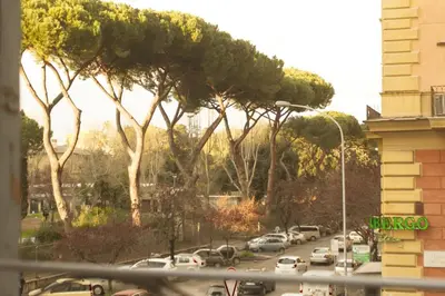 a street with cars parked in a parking lot with trees at Green House in San Lorenzo Termini in Rome