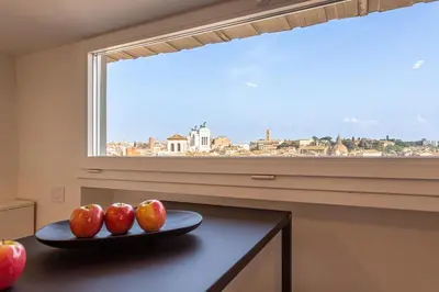 a patio with a table and chairs on a balcony at Arenula16 - Attico con terrazza panoramica in Rome