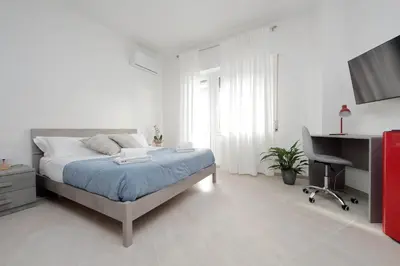 a white bedroom with a bed and a desk at 4BNB - The Dome TwentyFive in Rome