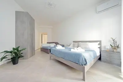 a bedroom with two beds and a plant in it at 4BNB - The Dome TwentyFive in Rome