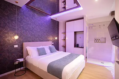 a bedroom with a large bed and a purple wall at Rome suite Rome Vaticano Guest house in Rome