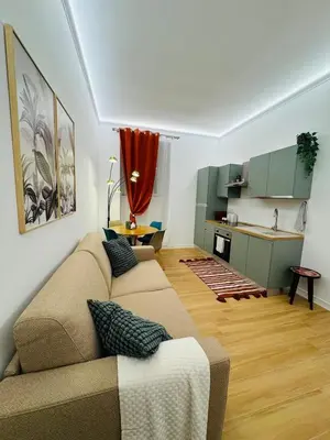 a living room with a couch and a kitchen at Friendly Apartment San Saba in Rome