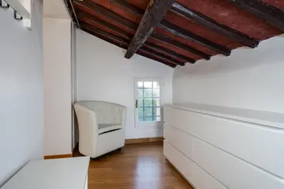a room with a white chair and a window at Fabuloucity Fontana di Trevi in Rome