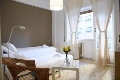 a bedroom with a bed and a table with flowers on it at Cesare a Trastevere in Rome