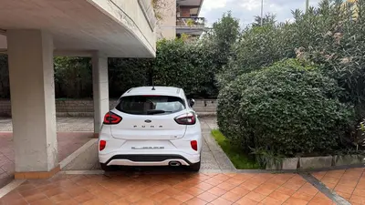 a white car parked next to a building at La Casetta tiny house in Rome in Rome