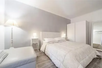 a white bedroom with a large bed and a table at Awesome in Rome