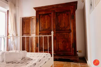 a bedroom with a wooden cabinet next to a bed at Gorgeous House Trastevere in Rome