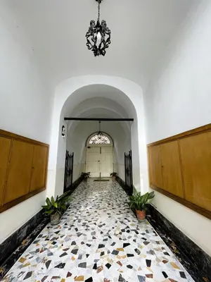an empty hallway with a chandelier and a tile floor at Enjoy Colosseo in Rome