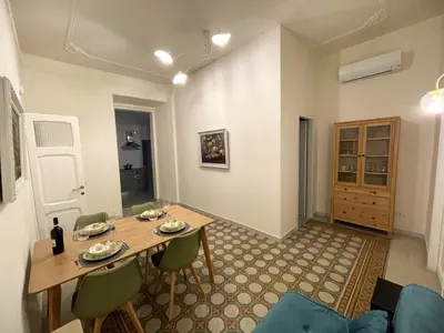 a dining room with a wooden table and green chairs at Enjoy Colosseo in Rome