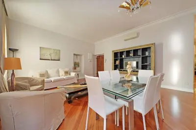 a living room with a glass table and white chairs at Capocci by Halldis in Rome