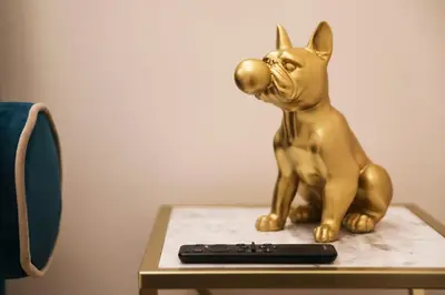 a gold cat statue sitting on a table next to a remote control at Lady A in Rome- Luxury Apartment in Rome