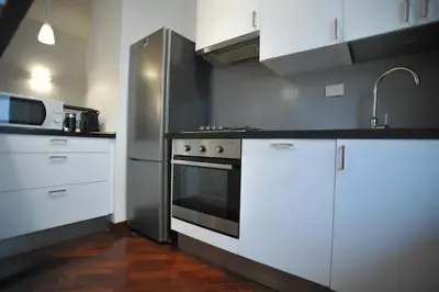 a kitchen with a stove and a refrigerator at Ponte Milvio Cozy 1BR Apartment in Rome