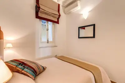 a white bedroom with a bed and a window at NEW Navona Bright Apartment in Rome