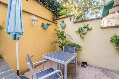 a table and chairs and an umbrella on a patio at Cozy apartment in Trastevere with patio - AC in Rome