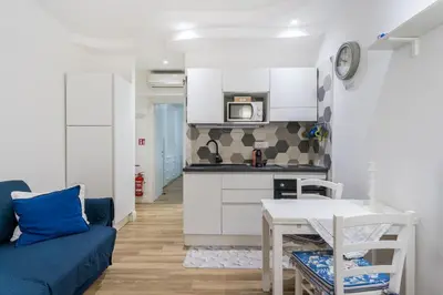 a living room with a table and a kitchen at Cozy apartment in Trastevere with patio - AC in Rome