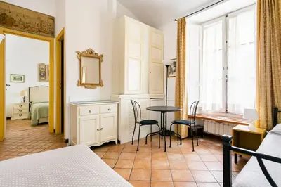 a bedroom with a table and chairs and a bed at Scipioni Suites in Rome