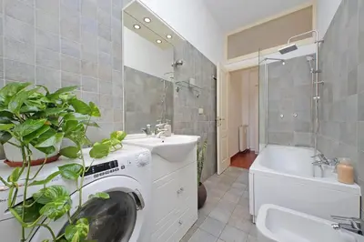 a bathroom with a washing machine and a sink at Modern Apartment near Metro Malatesta with Balcony & Wi-Fi in Rome