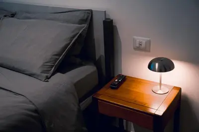 a nightstand with a lamp on a table next to a bed at Testaccio Dream House in Rome