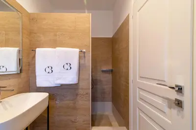 a bathroom with white towels and a shower at Casa Barbieri boutique apartment Borgo Pio in Rome