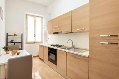 a kitchen with wooden cabinets and a sink at Vaticano San Pietro - Marisa Home - Check-in h24 in Rome