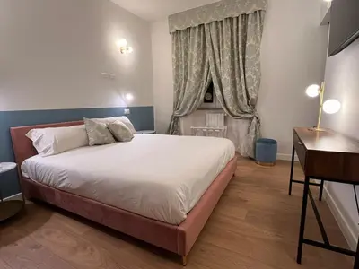 a bedroom with a bed and a desk and a window at Paolina Place in Rome