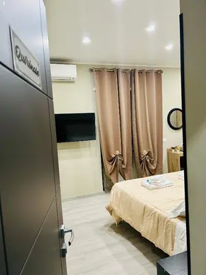 a room with a bed with curtains and a television at Cappadocia Rooms in Rome