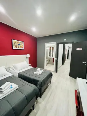 a room with two beds and a red wall at Cappadocia Rooms in Rome