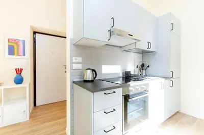 a white kitchen with a sink and a stove at Trendy apartment at Vatican in Rome