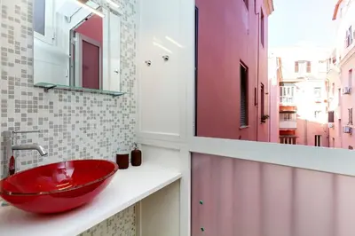 a bathroom with a red sink and a mirror at Trendy apartment at Vatican in Rome
